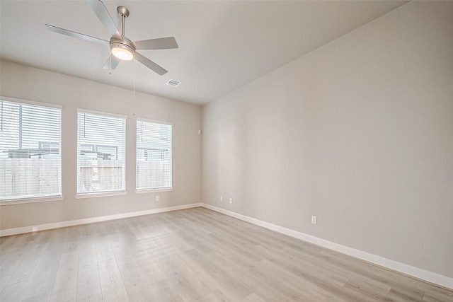 spare room featuring light wood-style flooring, baseboards, and visible vents