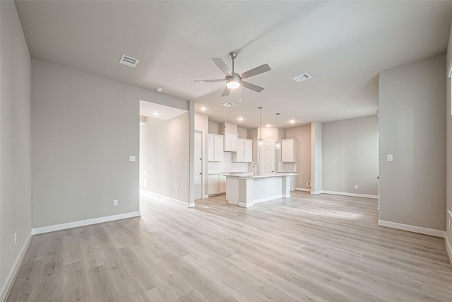 unfurnished living room featuring visible vents, a ceiling fan, and light wood-style floors