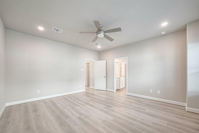 unfurnished bedroom with light wood-type flooring, baseboards, visible vents, and ensuite bath