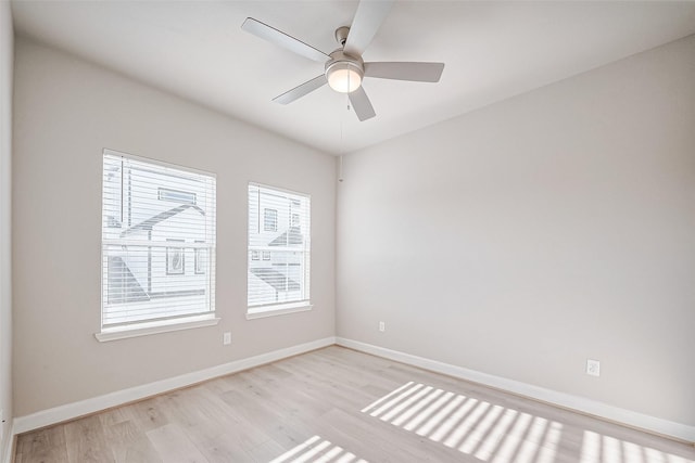 spare room featuring light wood-style flooring, ceiling fan, and baseboards