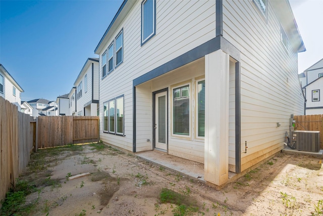back of house featuring central AC, a fenced backyard, and a patio