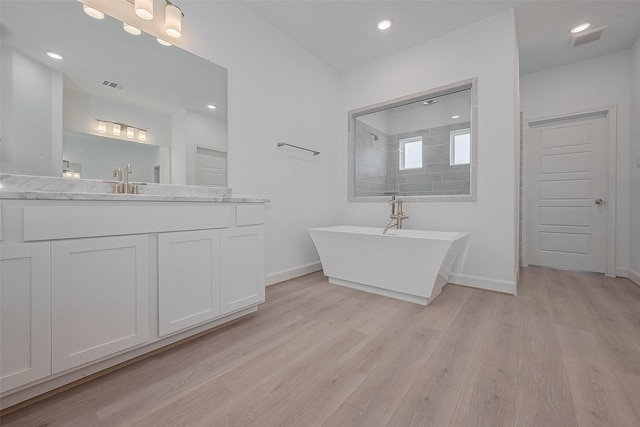 1611 Regents Gate Ct, Houston, TX 77055 - full bath with wood finished floors, a freestanding tub, baseboards, vanity, and a shower