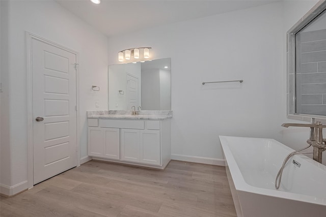 1611 Regents Gate Ct, Houston, TX 77055 - bathroom with wood finished floors, baseboards, a soaking tub, vanity, and recessed lighting