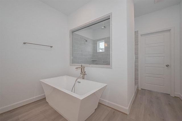 1611 Regents Gate Ct, Houston, TX 77055 - bathroom with wood finished floors, baseboards, tiled shower, and a soaking tub