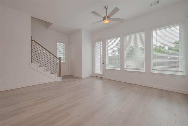 1611 Regents Gate Ct, Houston, TX 77055 - unfurnished living room featuring light wood-style floors, baseboards, ceiling fan, and stairway