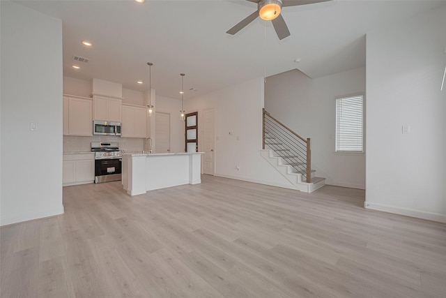 1611 Regents Gate Ct, Houston, TX 77055 - unfurnished living room featuring a sink, ceiling fan, stairs, light wood-style flooring, and baseboards