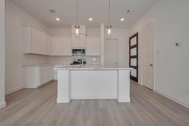 1611 Regents Gate Ct, Houston, TX 77055 - kitchen with appliances with stainless steel finishes, decorative backsplash, light wood-style floors, white cabinetry, and recessed lighting