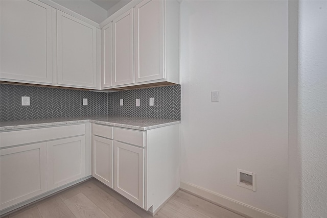 8928 Covenant Pl, Houston, TX 77055 - kitchen with decorative backsplash, light countertops, light wood-style flooring, and white cabinets