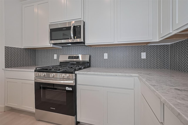 8928 Covenant Pl, Houston, TX 77055 - kitchen with appliances with stainless steel finishes, white cabinets, and light wood finished floors