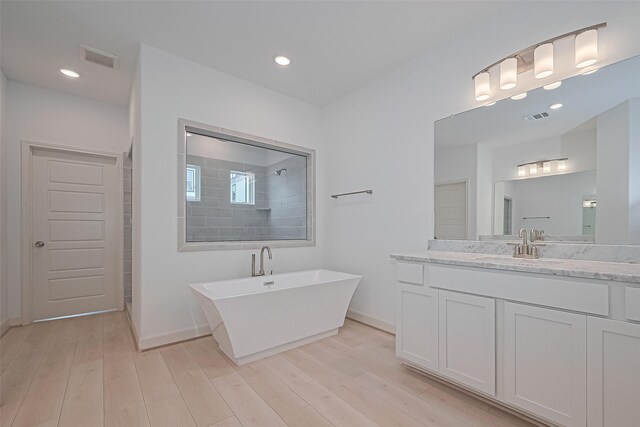 8928 Covenant Pl, Houston, TX 77055 - full bathroom featuring a freestanding tub, vanity, wood finished floors, baseboards, and recessed lighting