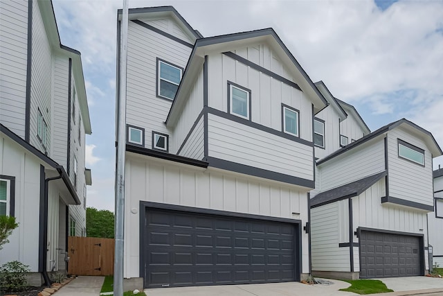 8928 Covenant Pl, Houston, TX 77055 - view of front of house with board and batten siding, a garage, and concrete driveway