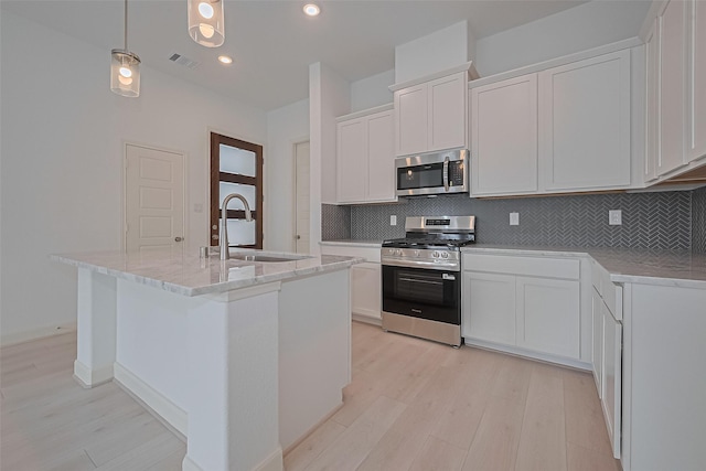 8928 Covenant Pl, Houston, TX 77055 - kitchen with stainless steel appliances, a sink, light wood-type flooring, tasteful backsplash, and recessed lighting