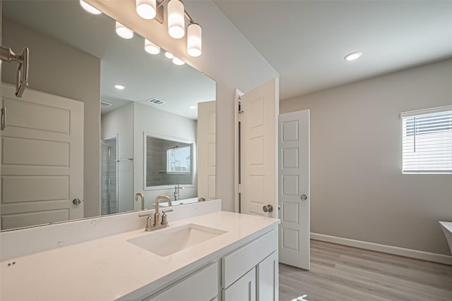 full bath featuring a shower with door, vanity, baseboards, visible vents, and wood finished floors