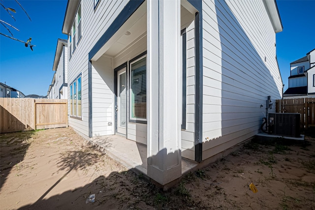 view of home's exterior with central air condition unit, a patio area, and fence