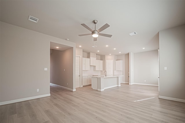 unfurnished living room with light wood-style floors, visible vents, baseboards, and ceiling fan