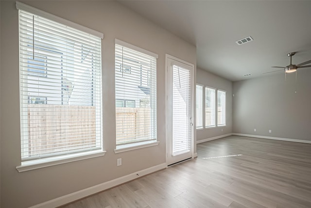 unfurnished room with visible vents, baseboards, wood finished floors, and ceiling fan