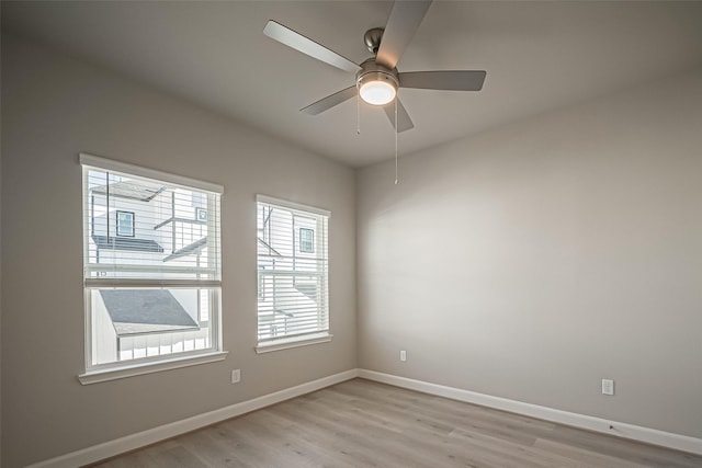 spare room with a wealth of natural light, light wood-style flooring, and baseboards