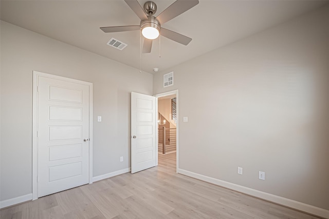 unfurnished bedroom featuring visible vents, baseboards, ceiling fan, and light wood-style floors