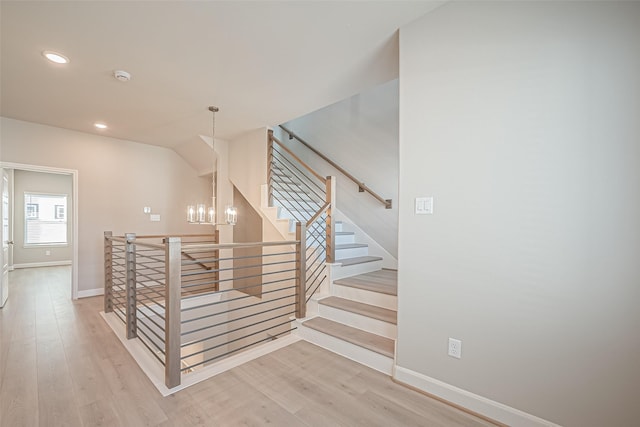 stairway featuring baseboards, recessed lighting, an inviting chandelier, and wood finished floors