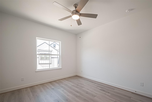 spare room with light wood-style floors, baseboards, and a ceiling fan