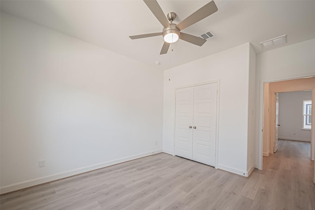 unfurnished bedroom featuring light wood finished floors, visible vents, a closet, and baseboards