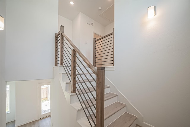 staircase featuring recessed lighting, attic access, and wood finished floors