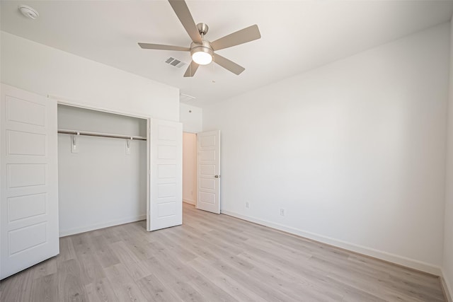 unfurnished bedroom with a closet, light wood finished floors, baseboards, and visible vents