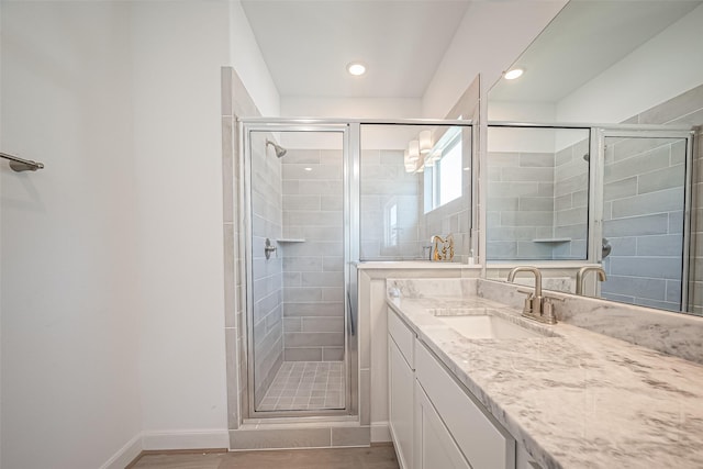 full bathroom featuring vanity, baseboards, a stall shower, recessed lighting, and wood finished floors
