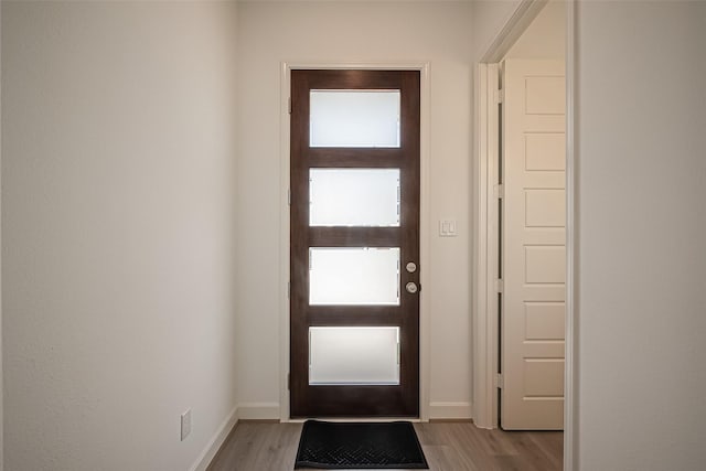 doorway to outside featuring light wood-style floors and baseboards