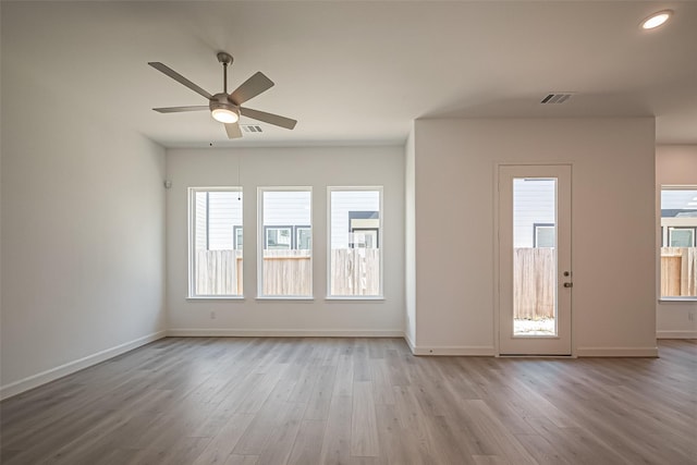 foyer entrance with ceiling fan, a wealth of natural light, and wood finished floors