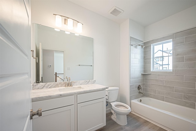 bathroom featuring vanity, visible vents,  shower combination, toilet, and wood finished floors