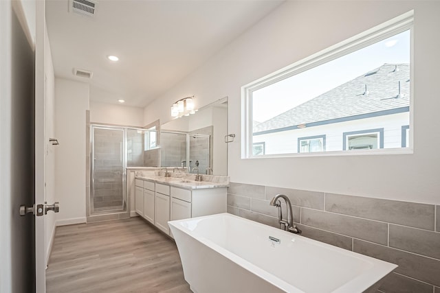 bathroom featuring a shower stall, vanity, visible vents, and wood finished floors