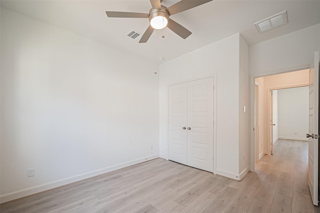 unfurnished bedroom with visible vents, baseboards, light wood finished floors, and a closet