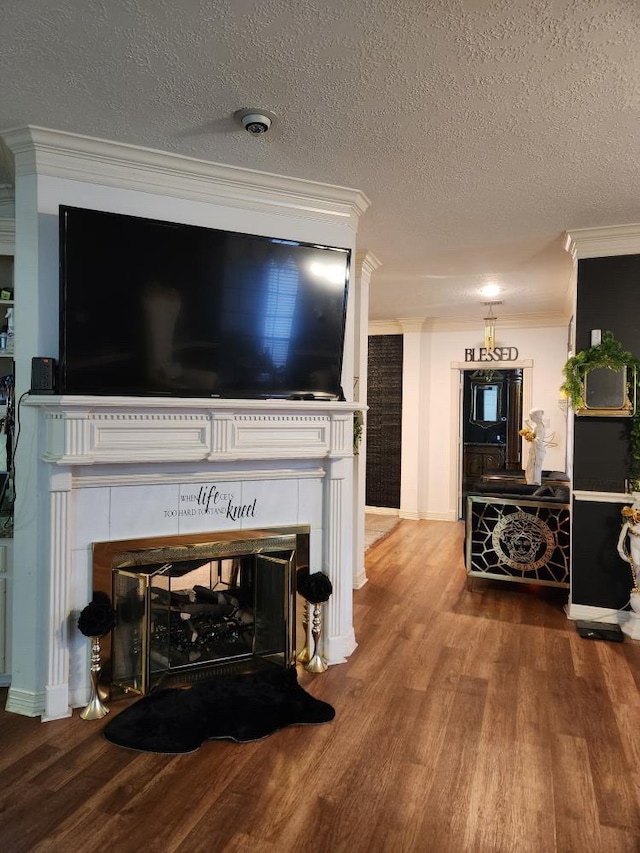 3226 Blackcastle Dr, Houston, TX 77068 - living room featuring a tile fireplace, crown molding, a textured ceiling, and wood finished floors