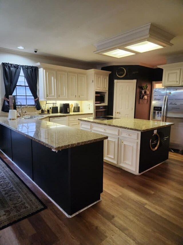 3226 Blackcastle Dr, Houston, TX 77068 - kitchen featuring light stone counters, a center island, appliances with stainless steel finishes, and a sink