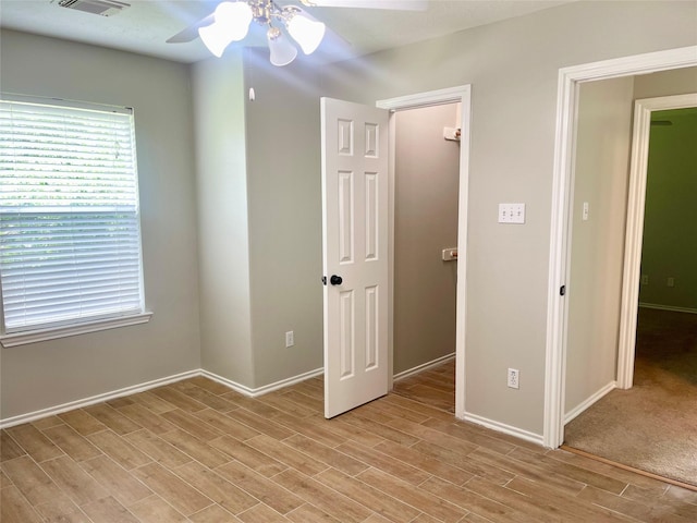 15318 Redbud Berry Way, Cypress, TX 77433 - unfurnished bedroom featuring baseboards, multiple windows, light wood-style floors, and a ceiling fan