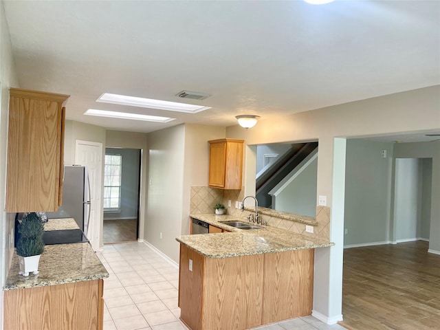 15318 Redbud Berry Way, Cypress, TX 77433 - kitchen featuring baseboards, a peninsula, visible vents, decorative backsplash, and a sink