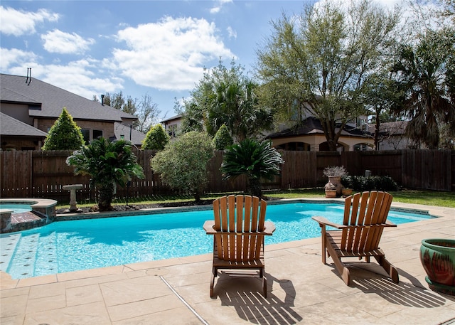 view of swimming pool featuring a patio area, a fenced backyard, and a pool with connected hot tub