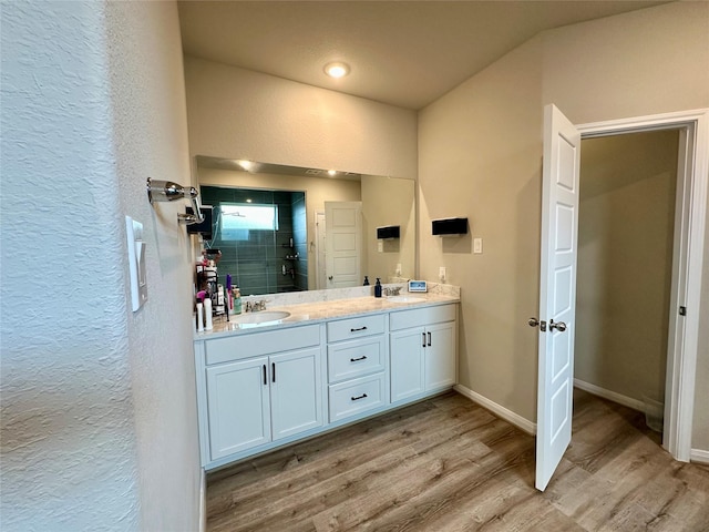 31503 Sandpiper Creek Dr, Hockley, TX 77447 - full bathroom featuring wood finished floors, a shower stall, double vanity, a textured wall, and baseboards