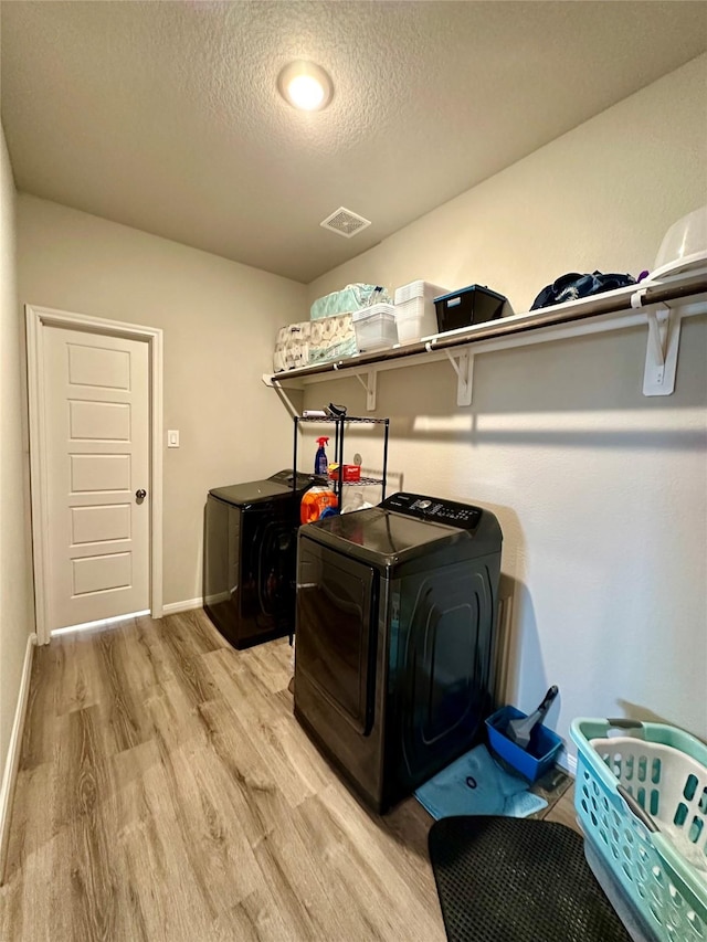31503 Sandpiper Creek Dr, Hockley, TX 77447 - laundry room with washer and dryer, light wood finished floors, a textured ceiling, and baseboards