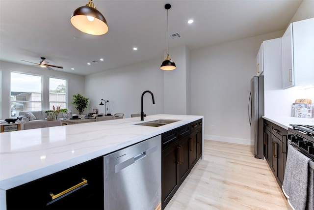 kitchen with light wood-style flooring, visible vents, a sink, hanging light fixtures, and stainless steel appliances
