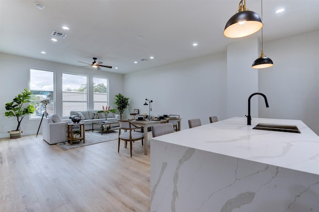 kitchen with recessed lighting, a sink, and hanging light fixtures