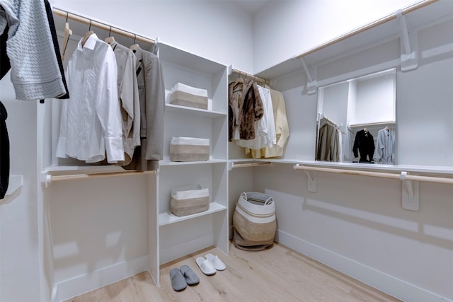walk in closet with wood finished floors