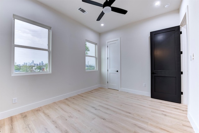 unfurnished room featuring a ceiling fan, visible vents, recessed lighting, wood finished floors, and baseboards