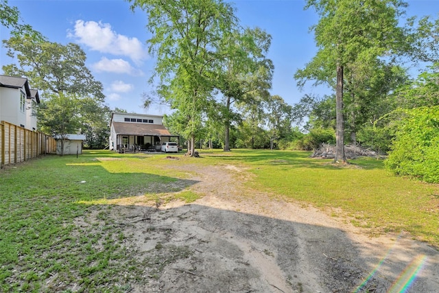 7926 Hennessy Ln, Spring, TX 77389 - view of yard featuring a detached carport, an outbuilding, driveway, and fence