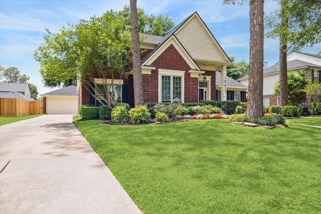 craftsman-style house featuring brick siding, a detached garage, a front yard, and fence