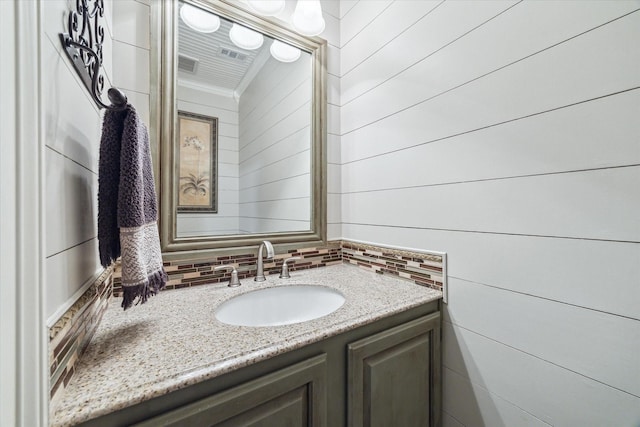 bathroom with tasteful backsplash and vanity