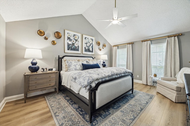 bedroom with light wood-type flooring, vaulted ceiling, baseboards, and a textured ceiling