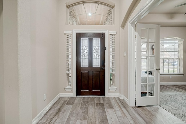 foyer entrance featuring baseboards and wood finished floors