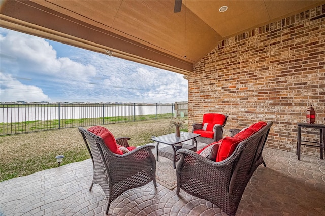 view of patio / terrace featuring a water view, a fenced backyard, and outdoor lounge area